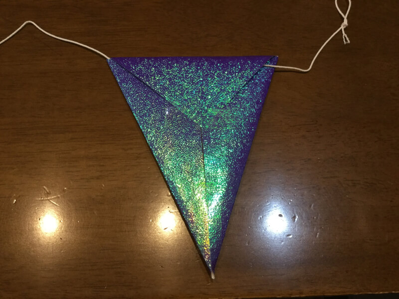 ハロウィンの製作で折り紙の飾りをタコ糸につなげている写真