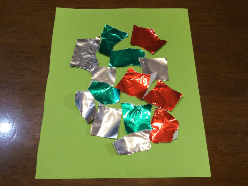 クリスマスの製作で画用紙に折り紙を貼り付けている写真