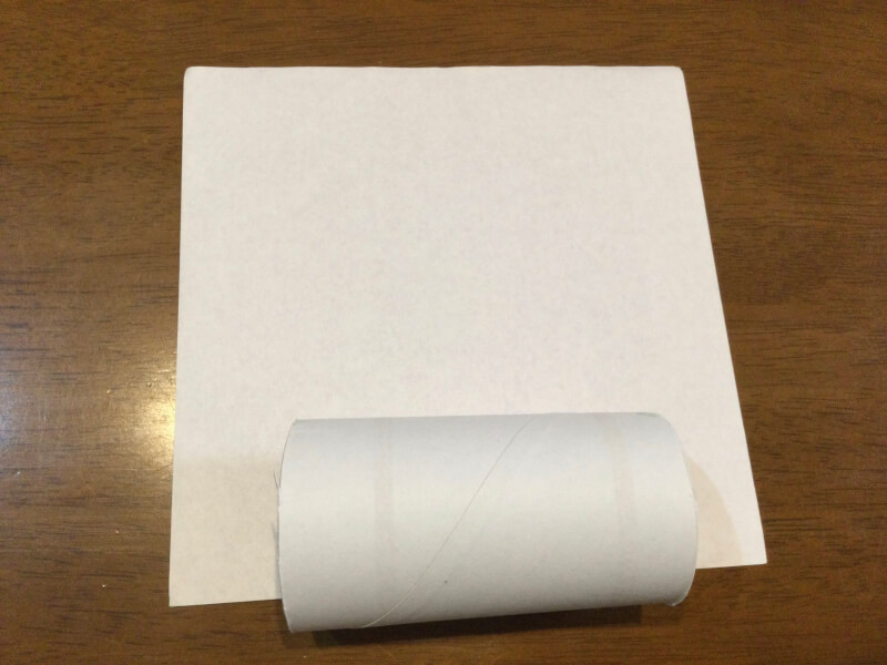 節分の製作で折り紙にトイレットペーパーの芯を置いている写真
