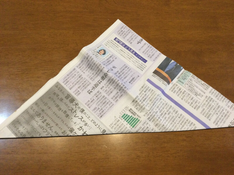 節分の製作で新聞紙を折って三角にしている写真