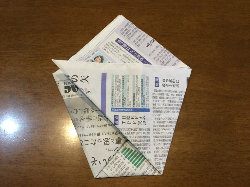 節分の製作で新聞紙を両端折っている写真