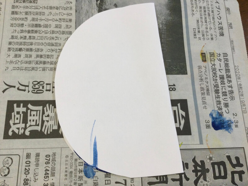 節分の製作で画用紙を二つに折りたたんでいる写真