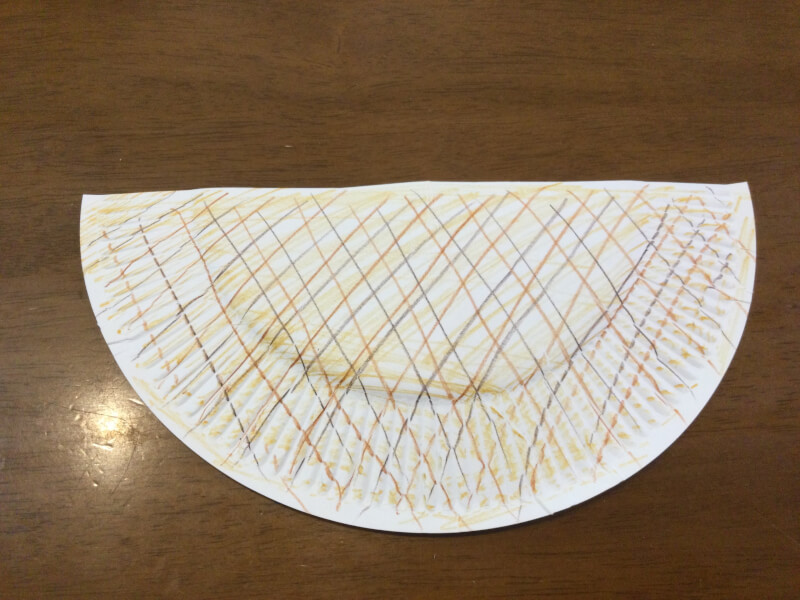 夏の遊び製作で紙皿に模様を描いている写真