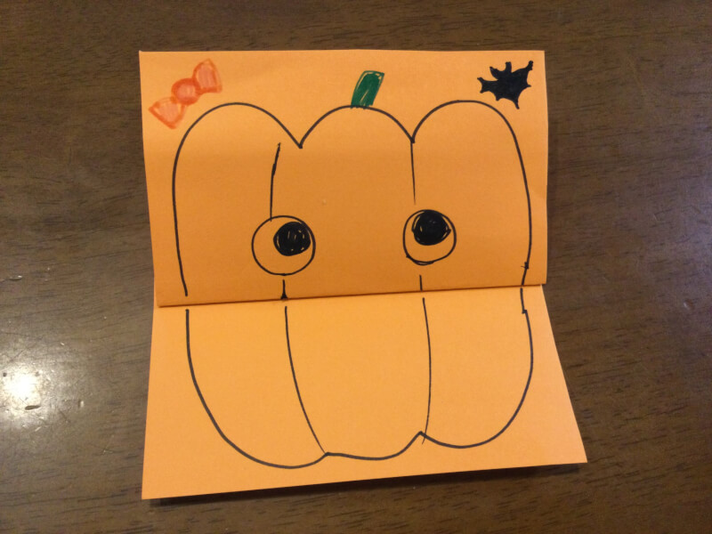 ハロウィンの製作でかぼちゃの顔を描いている写真