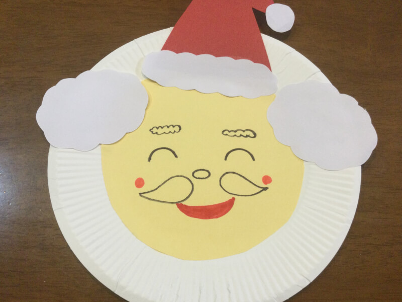 クリスマスの製作でサンタさんの顔を描いている写真