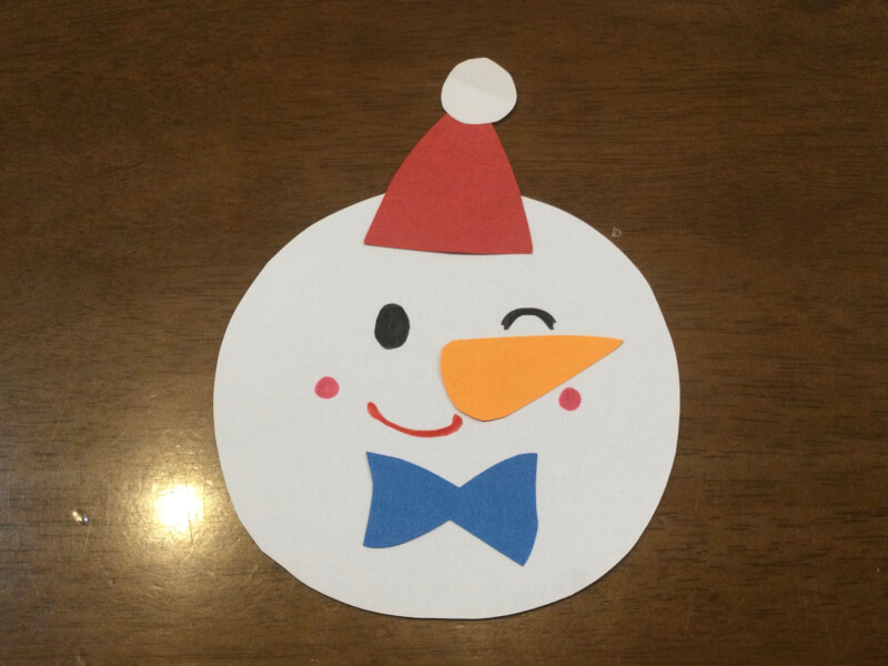 クリスマスの製作で雪だるまの顔を描いている写真