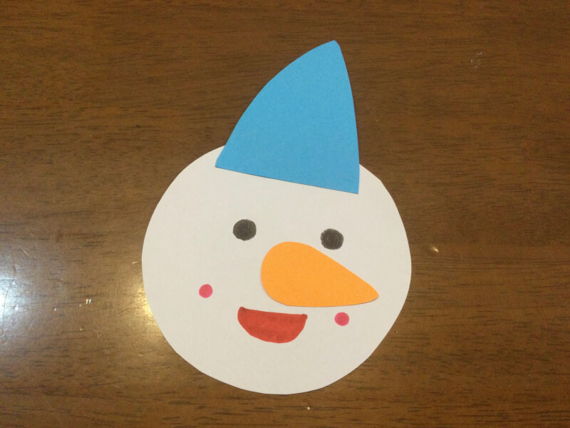 クリスマスの製作で雪だるまの顔を作っている写真
